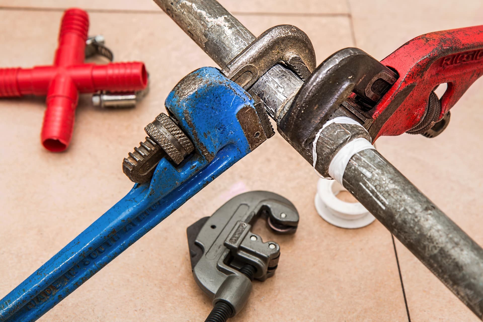Plumber wrenches being used to replace section of pinhole leak pipe